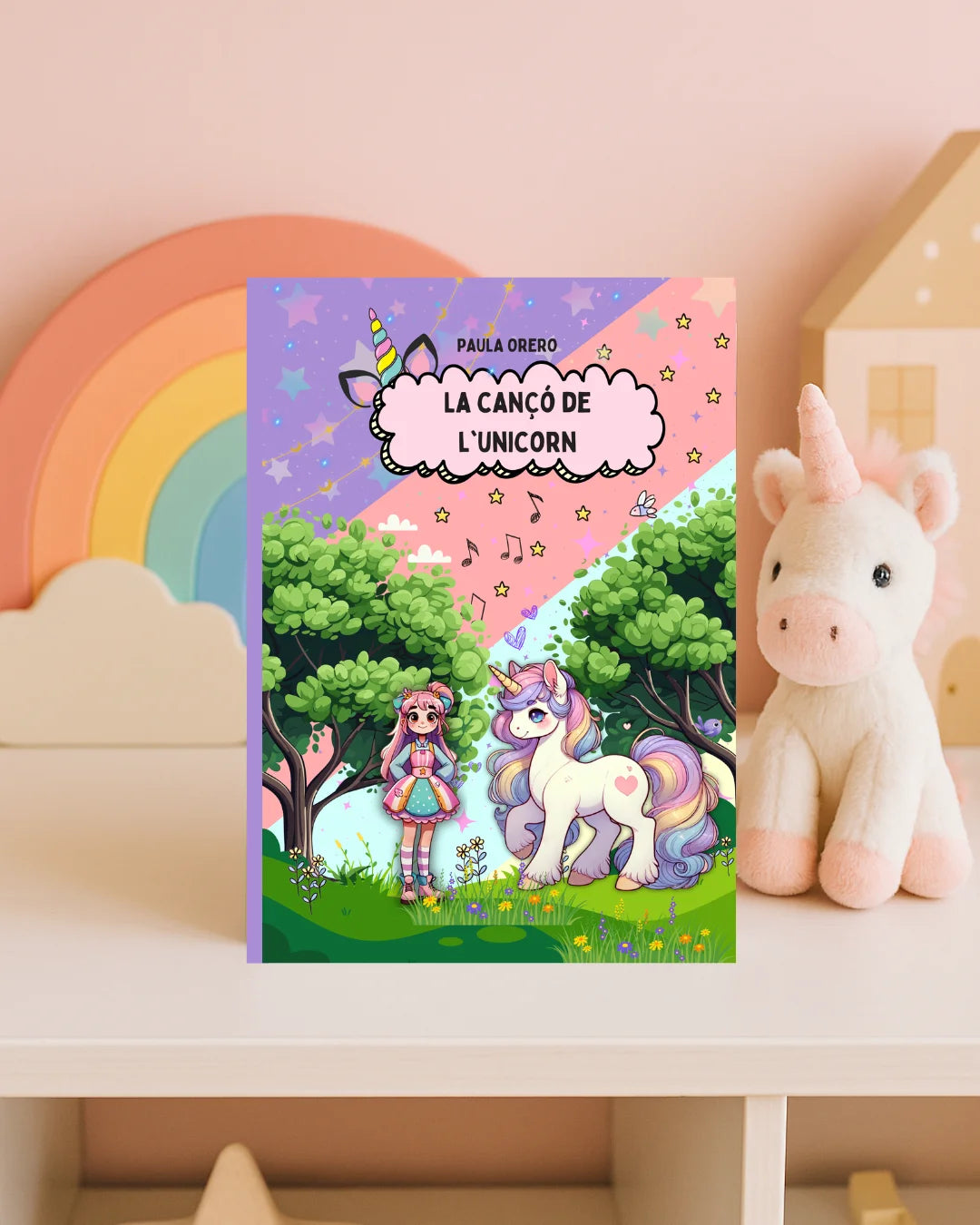 Libro infantil La Cançó de l'Unicorn de Paula Orero, con niña y unicornio en un bosque mágico de colores pastel en portada